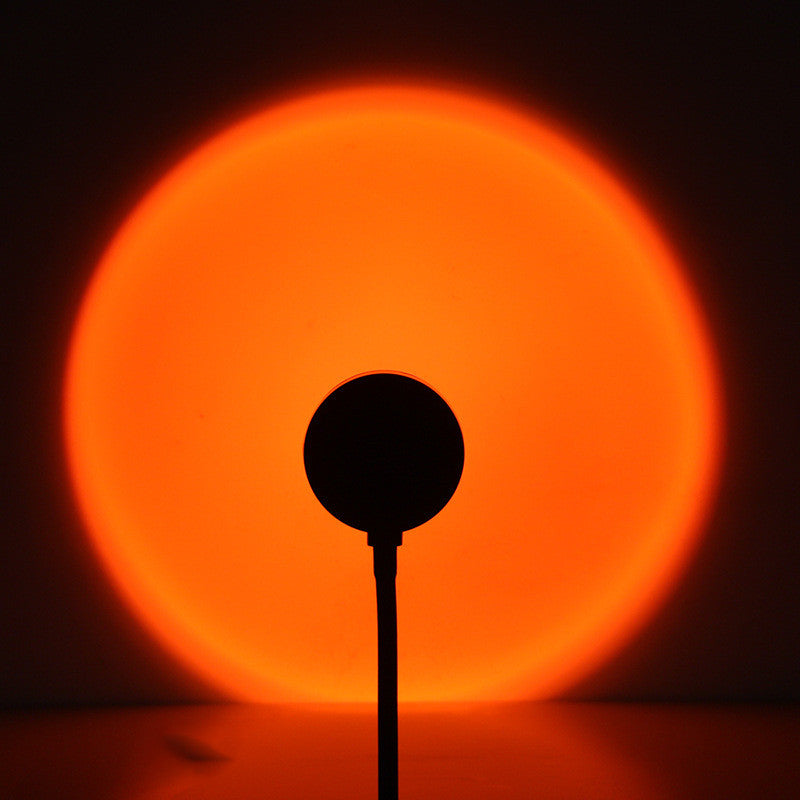Deep orange sunset disc filling the wall, cable running down to the floor
